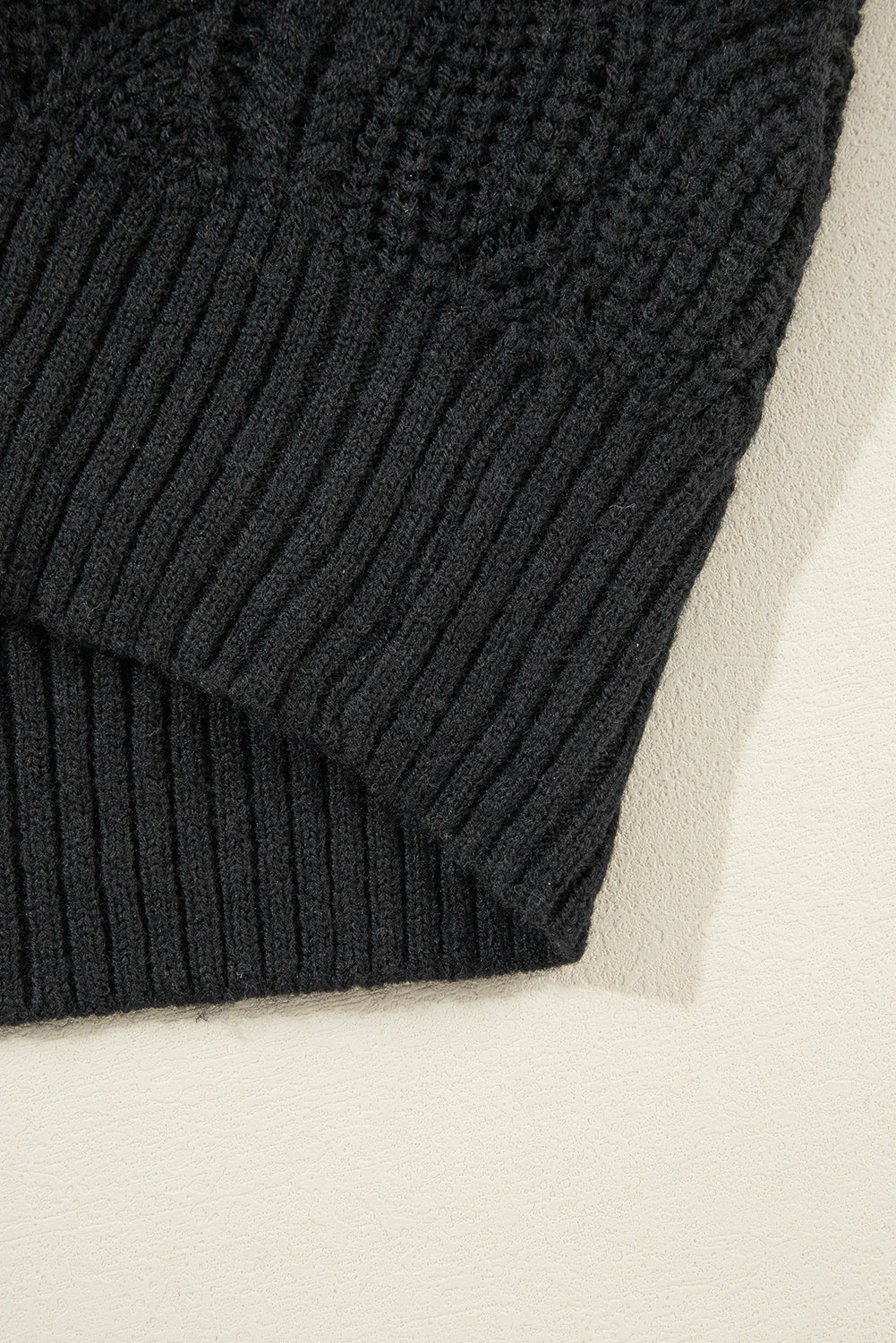 Schwarzer strickpullover mit v-ausschnitt und hohlen schultern