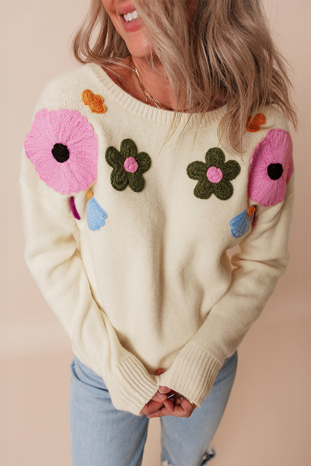 Beige gestrickter pullover mit blumenmuster und geripptem rand