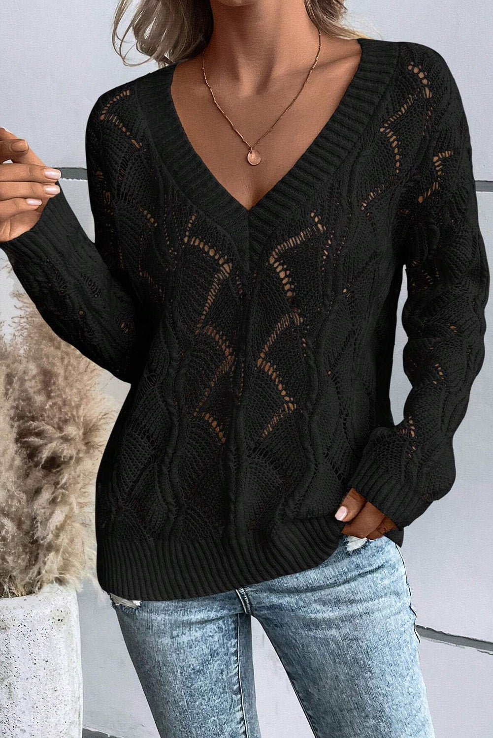Schwarzer strickpullover mit v-ausschnitt und hohlen schultern