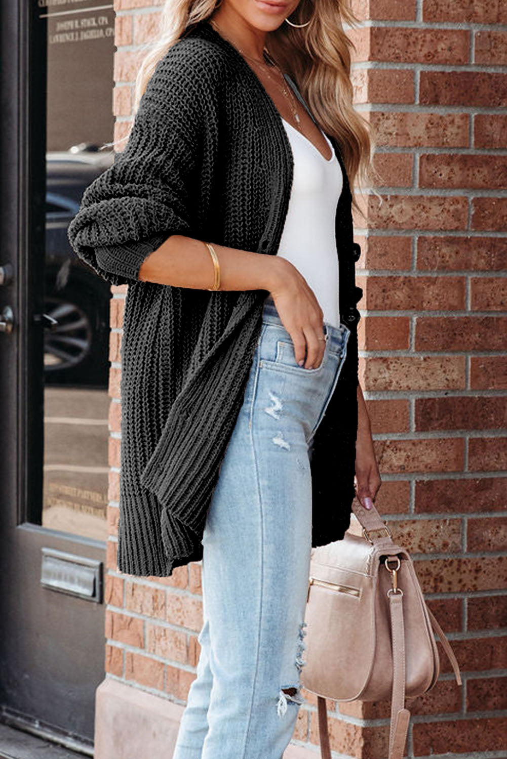 Schwarzer strickcardigan mit knöpfen an der vorderseite und hängeschultern
