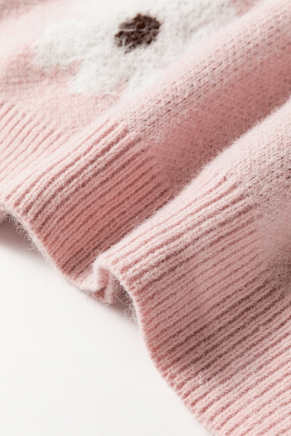 Rosafarbener pullover mit blumenmuster und halbem reißverschluss an den schultern