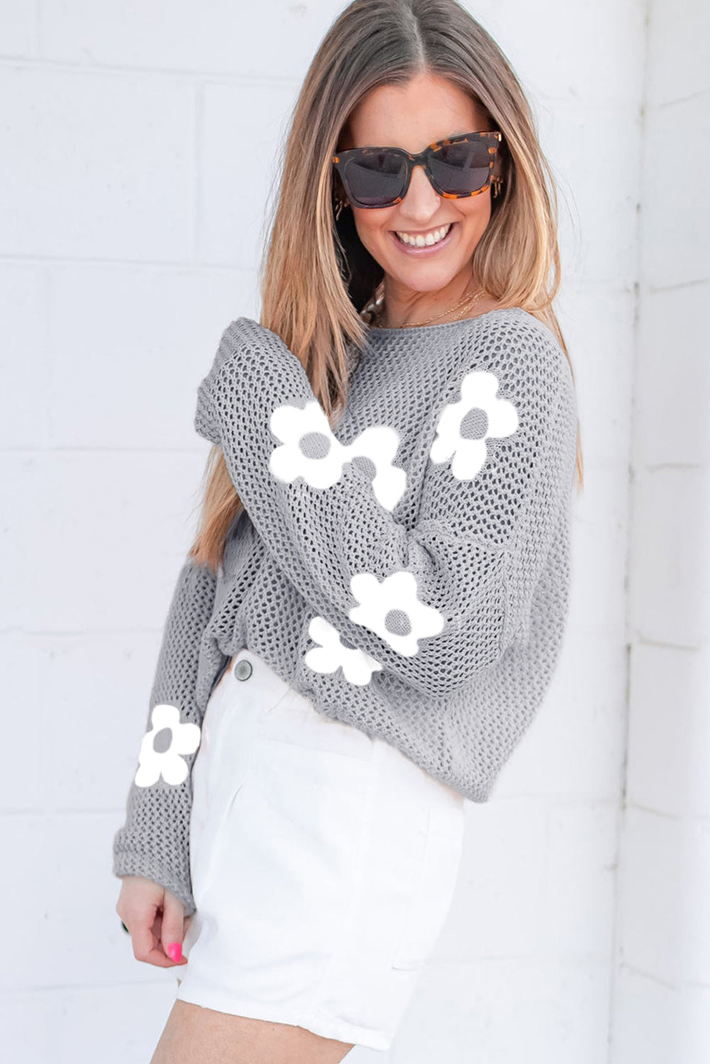 Hellgrauer pullover mit großer blume, hohl gestrickt und schulterfrei