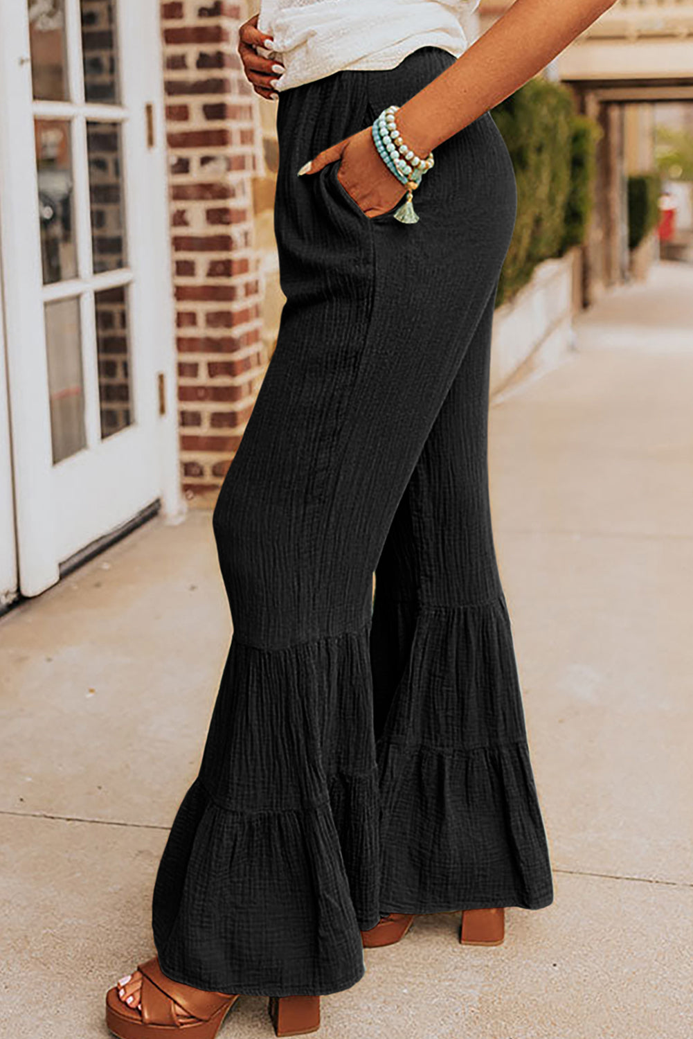 Schwarze strukturierte hose mit hoher taille und gerafftem glockenboden