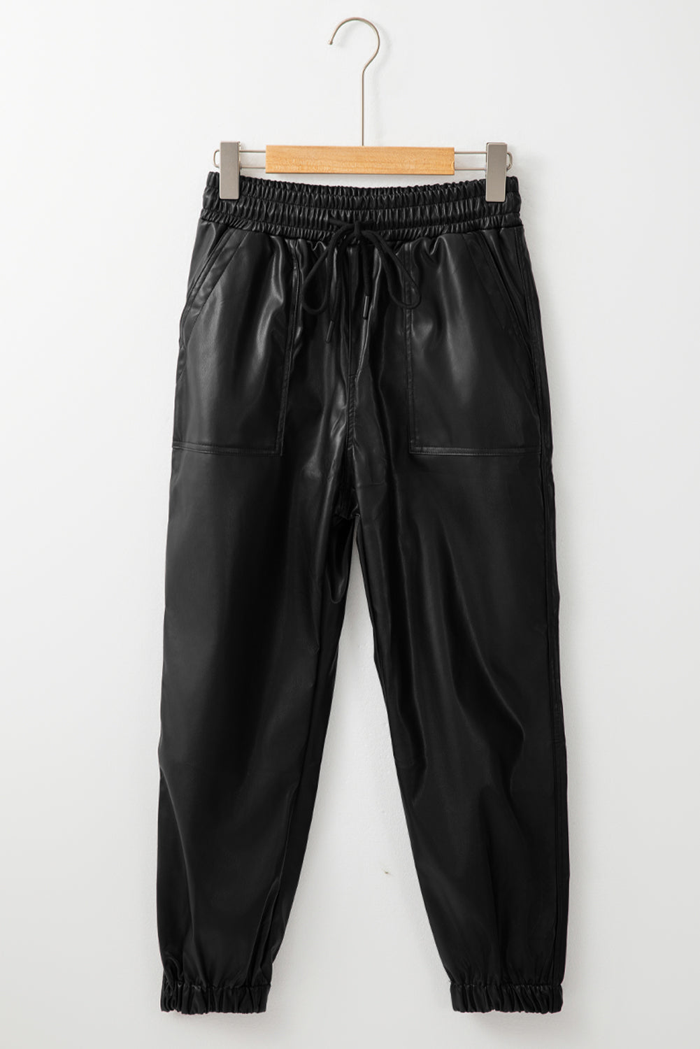 Schwarze kunstleder-jogginghose mit gesmokter taille und kordelzug