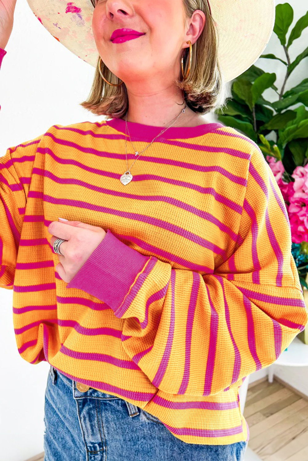 Orangefarbener gestreifter pullover mit rundhalsausschnitt und losen schultern