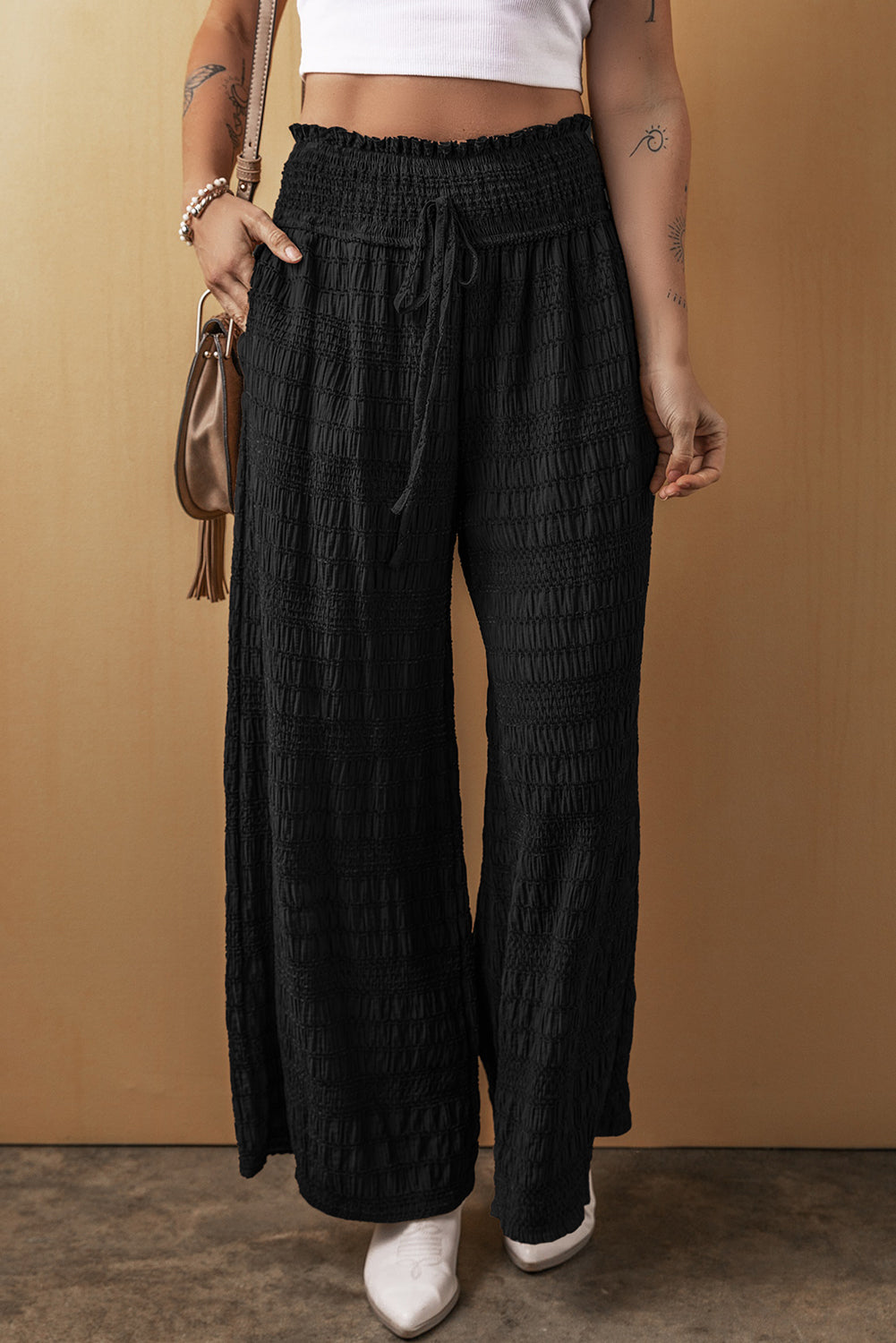 Schwarze strukturierte hose mit breiter gesmokter taille und loser hose