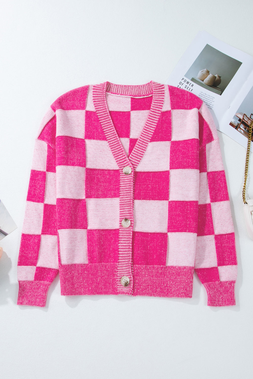 Rosa karierte strickjacke mit v-ausschnitt und geknöpften schultern