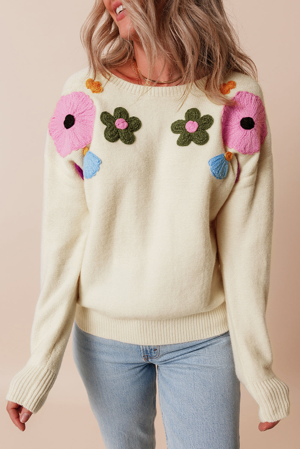 Beige gestrickter pullover mit blumenmuster und geripptem rand