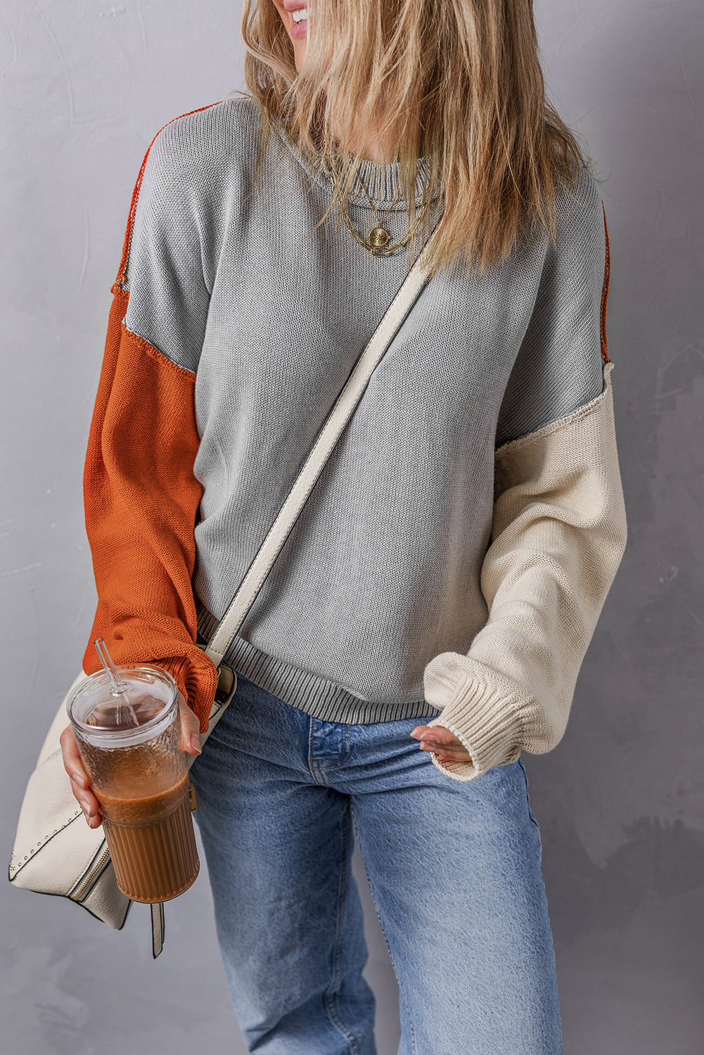 Grauer colorblock-pullover mit gerippten ärmeln und zierleisten