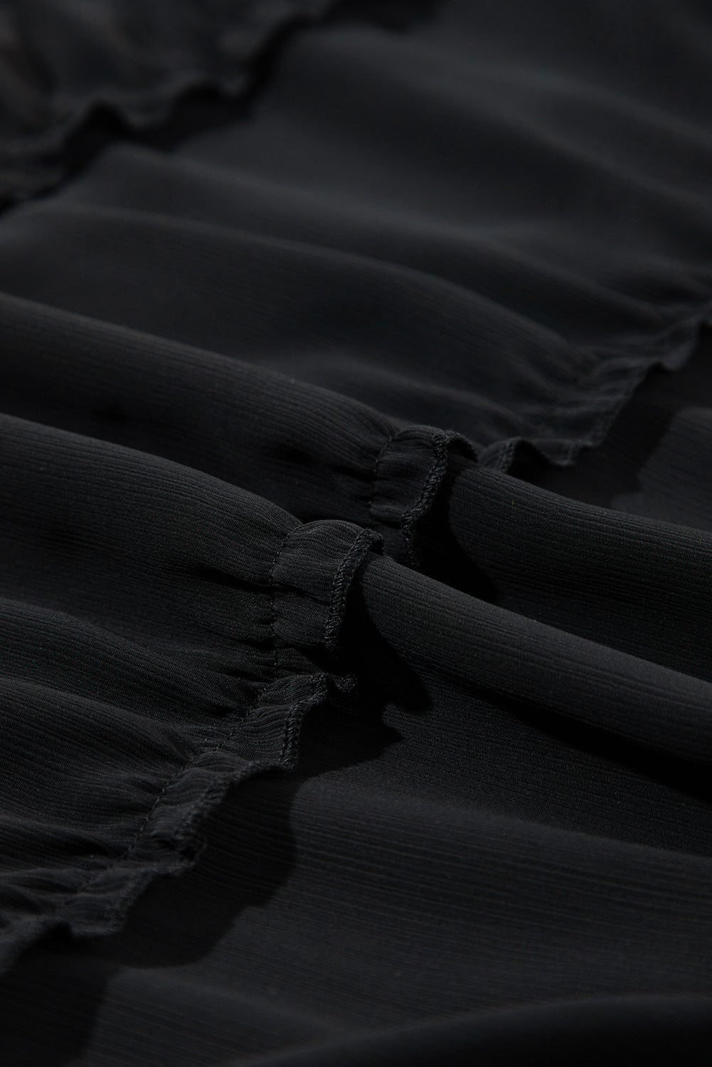 Schwarzes ärmelloses kleid mit v-ausschnitt und rüschenbesatz