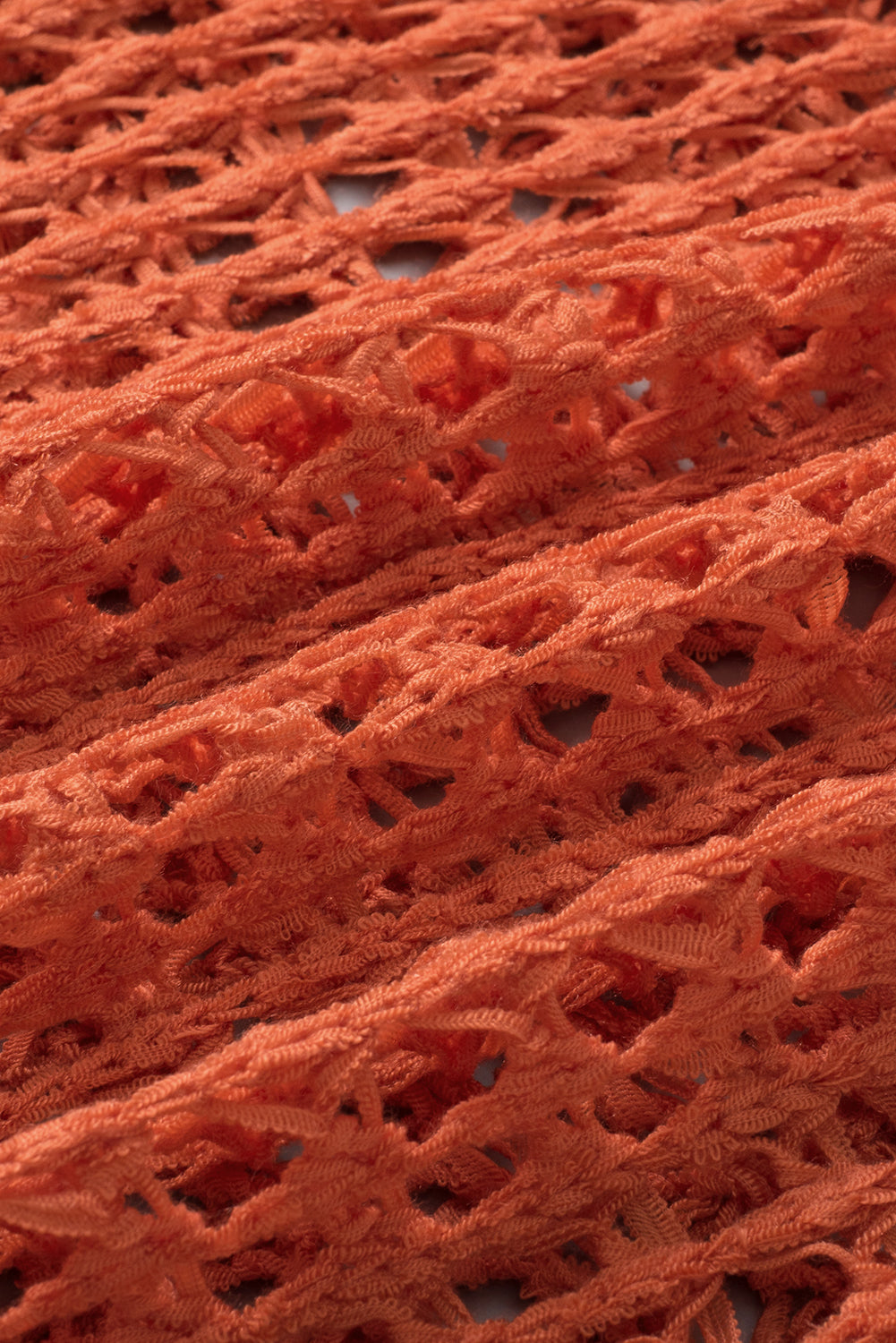 Orangefarbener tunika-pullover mit glockenärmeln und offenem häkelmuster