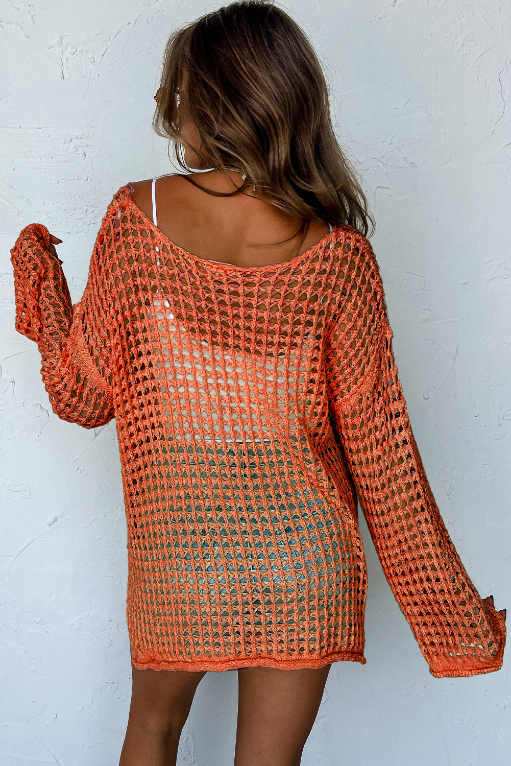 Orangefarbener tunika-pullover mit glockenärmeln und offenem häkelmuster