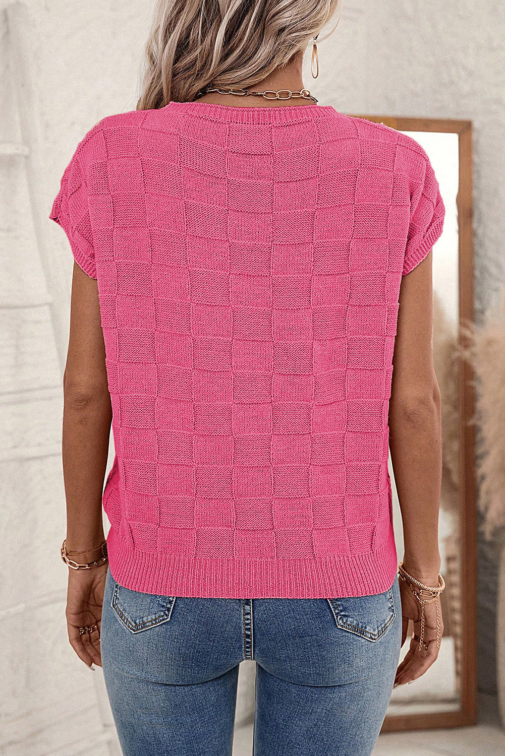 Leuchtend rosafarbener strickpullover mit kurzen ärmeln und gitterstruktur
