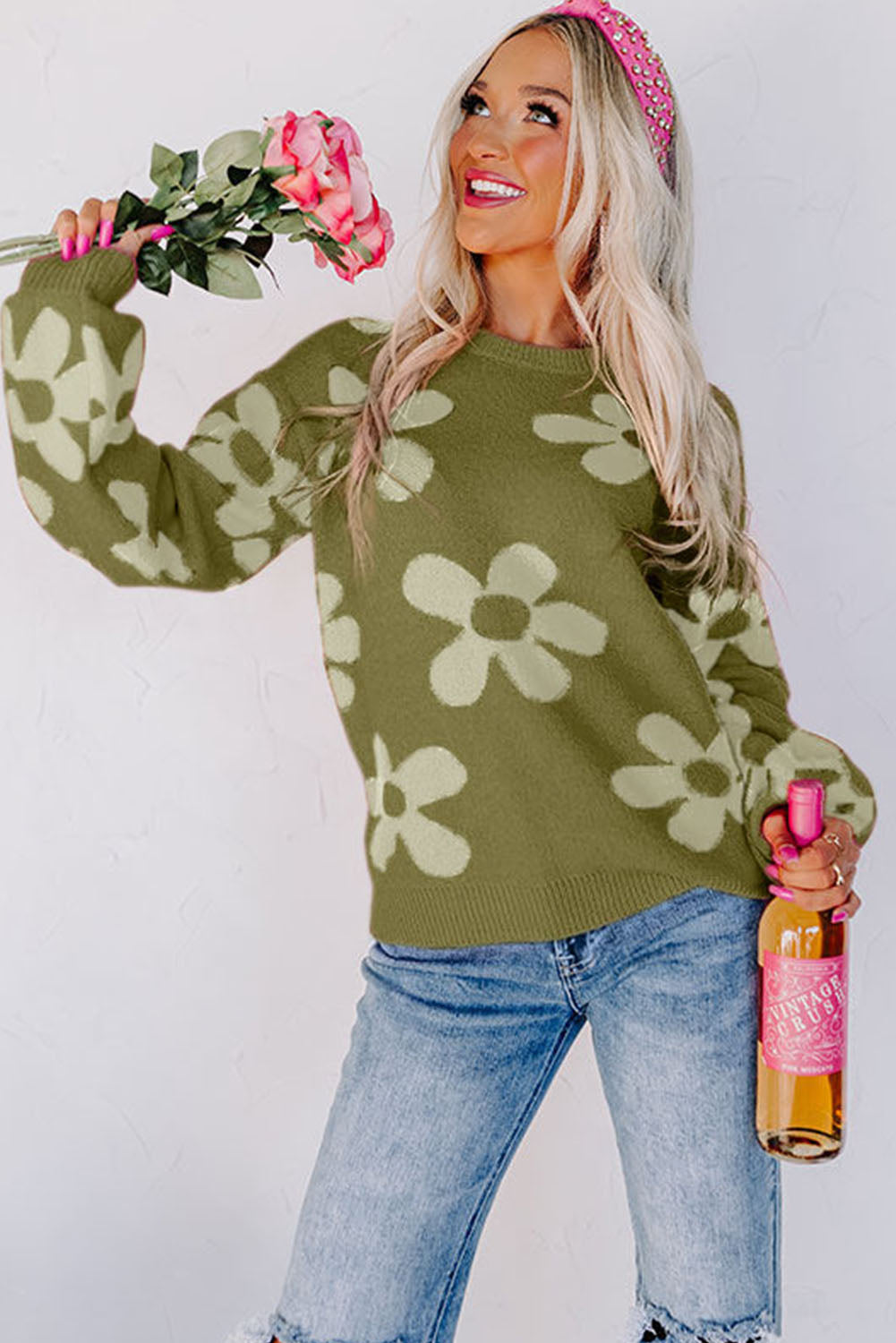Spinatgrüner pullover mit großer blume und rippstrickmuster