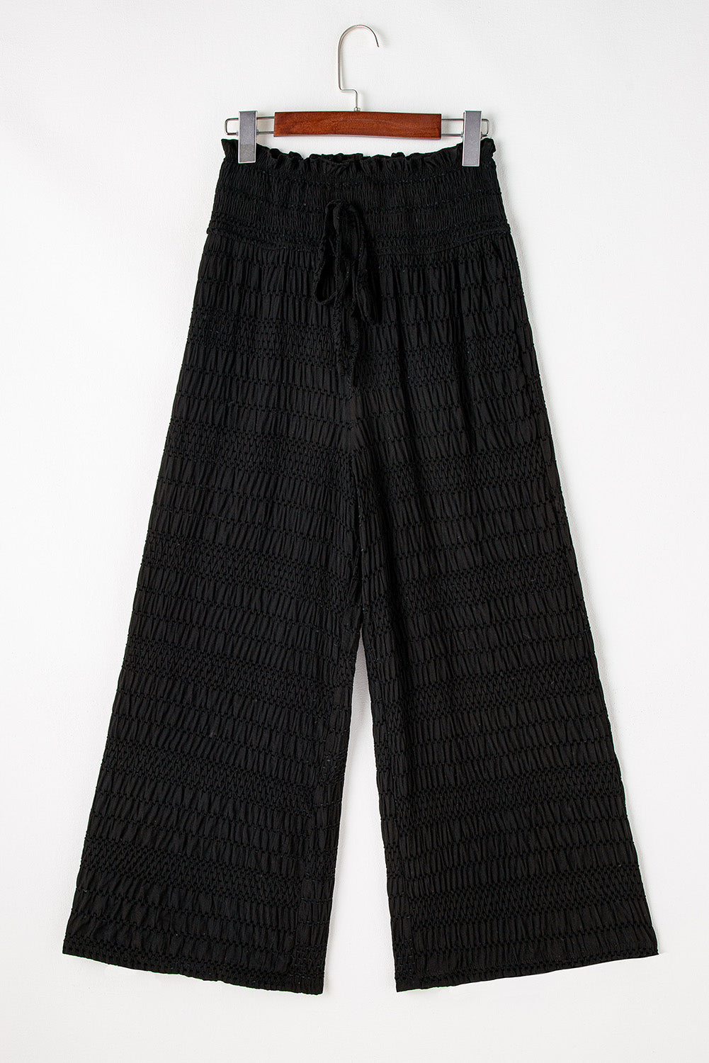 Schwarze strukturierte hose mit breiter gesmokter taille und loser hose