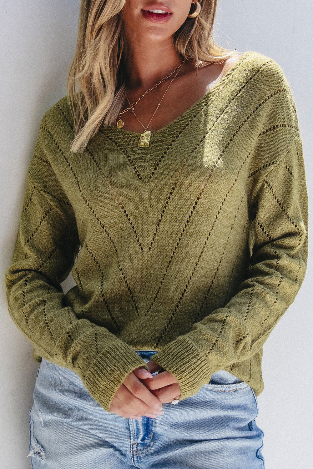 Salbeigrüner pullover mit v-ausschnitt und tropfenschulter in ösenform