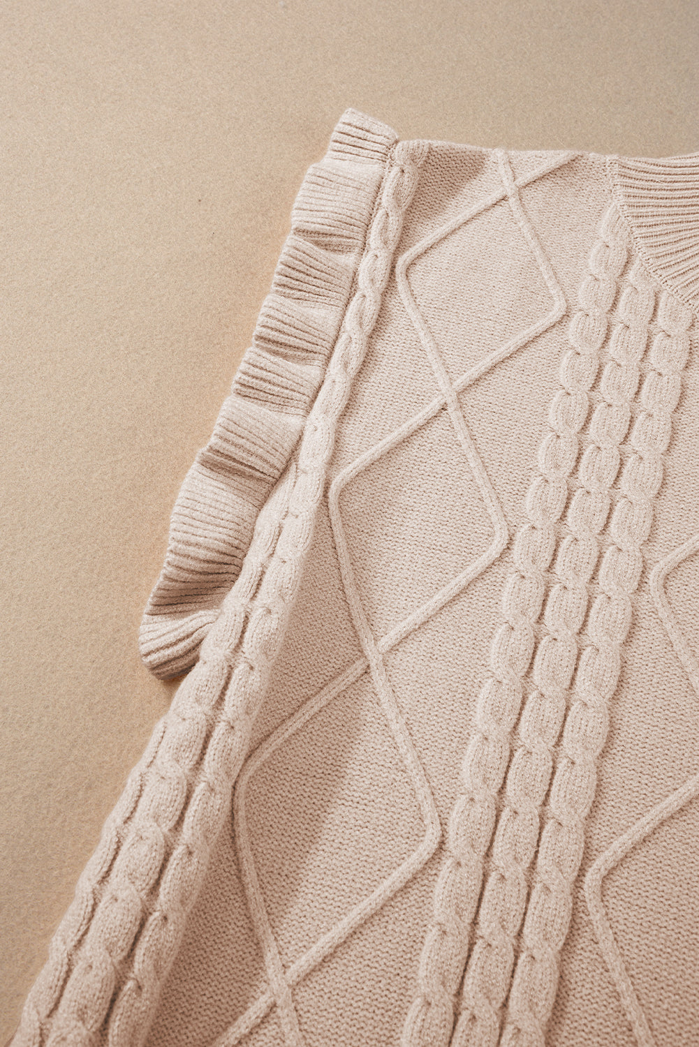 Pergamentfarbener kabelstrickpullover mit rollkragen und langen ärmeln