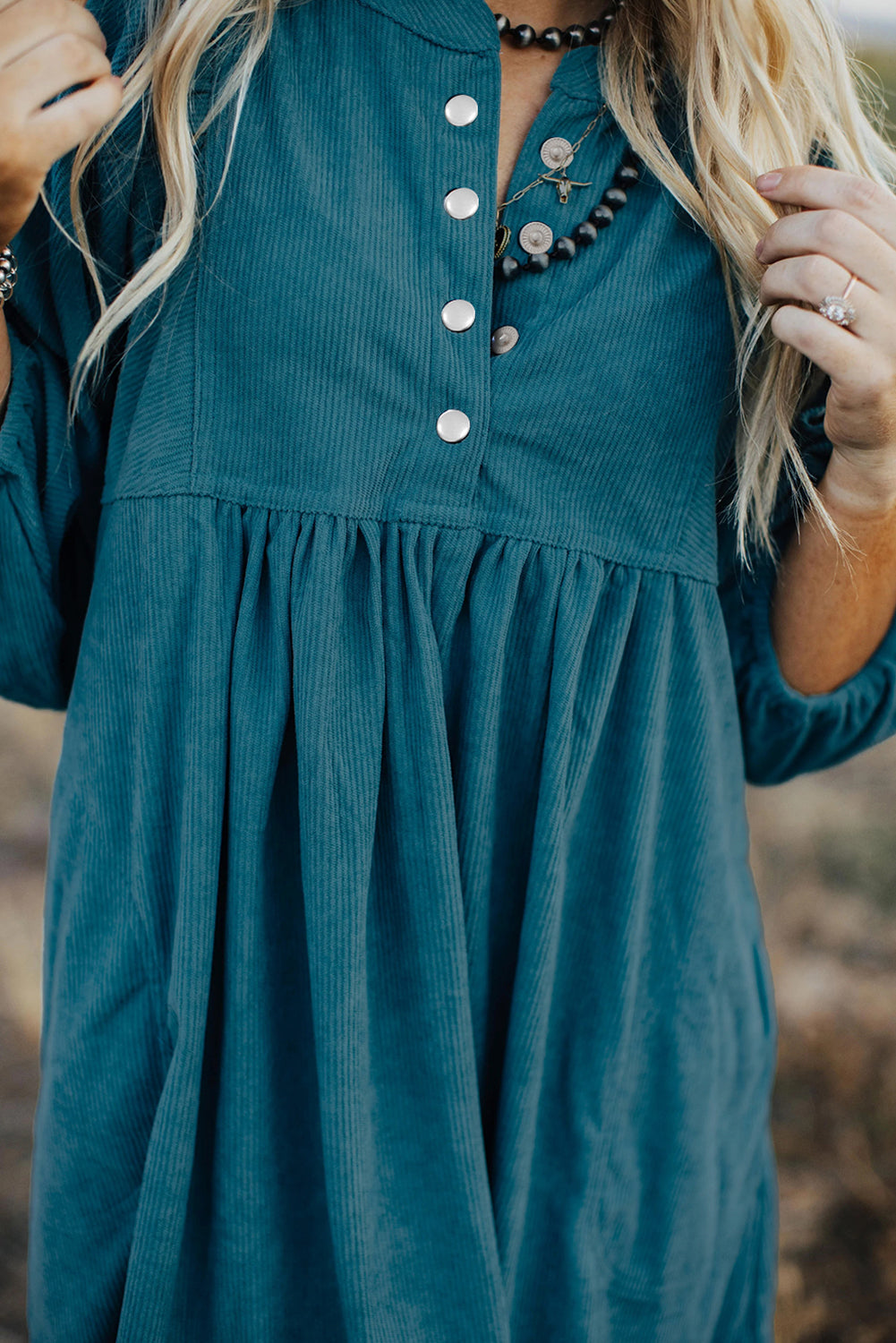 Blaues cord-knopf-kleid mit empire-taille und armband-ärmeln