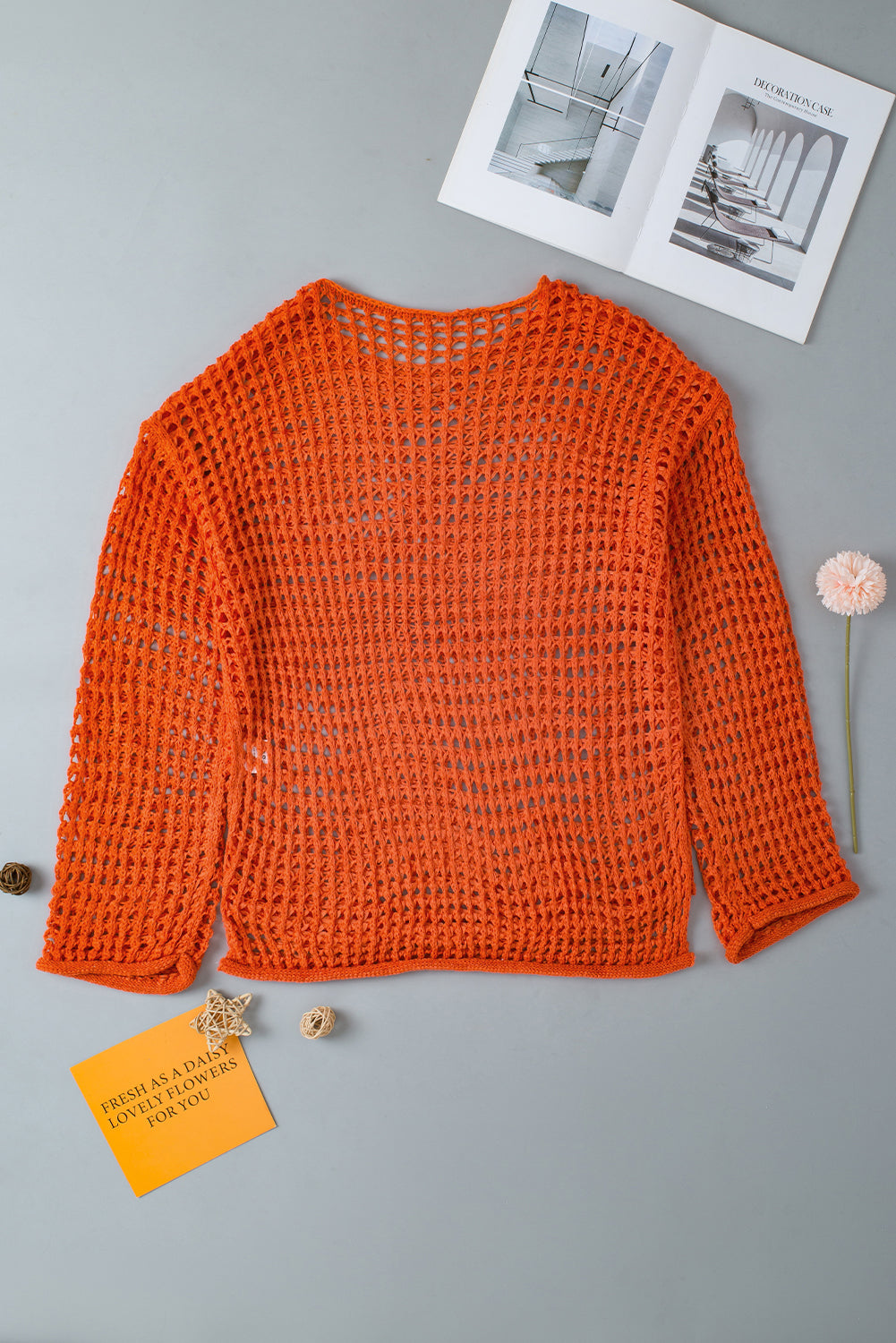 Orangefarbener tunika-pullover mit glockenärmeln und offenem häkelmuster