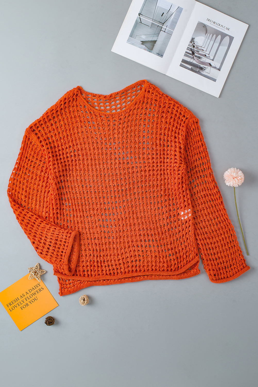 Orangefarbener tunika-pullover mit glockenärmeln und offenem häkelmuster