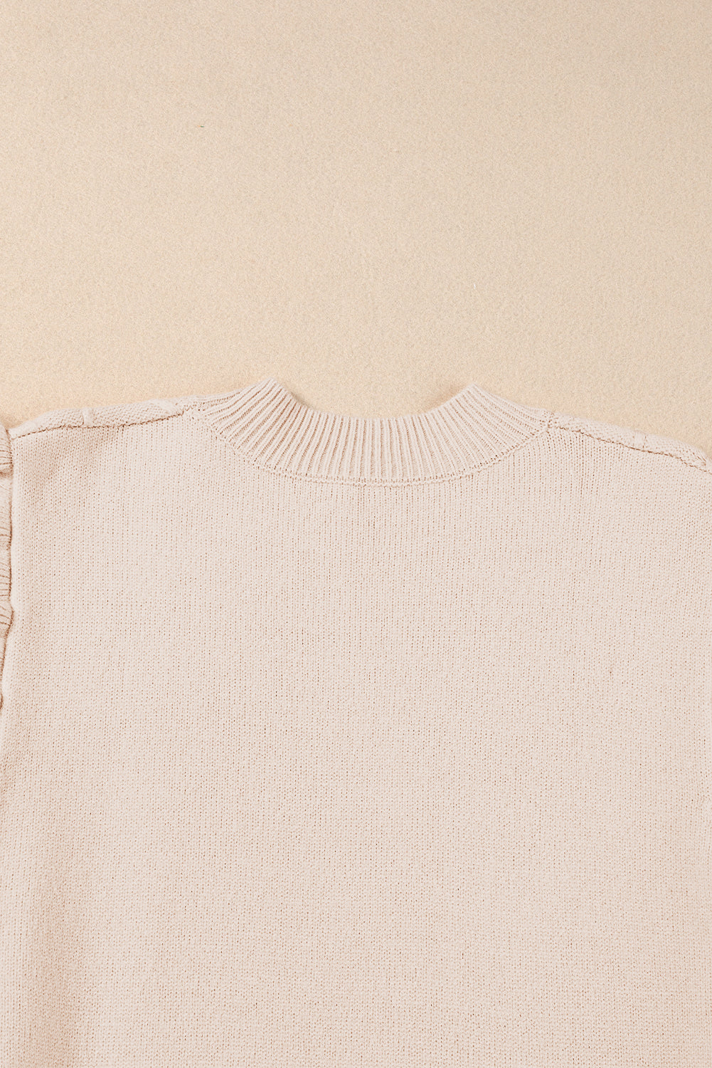 Pergamentfarbener kabelstrickpullover mit rollkragen und langen ärmeln