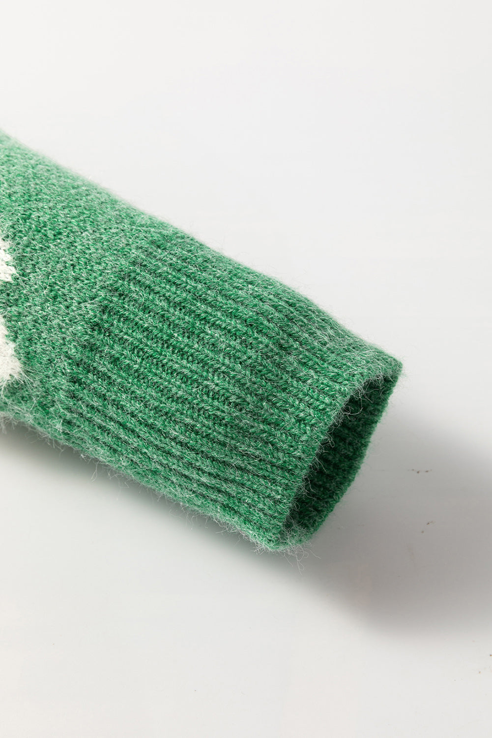 Grüner pullover mit floralem muster und halbem reißverschluss an der schulter