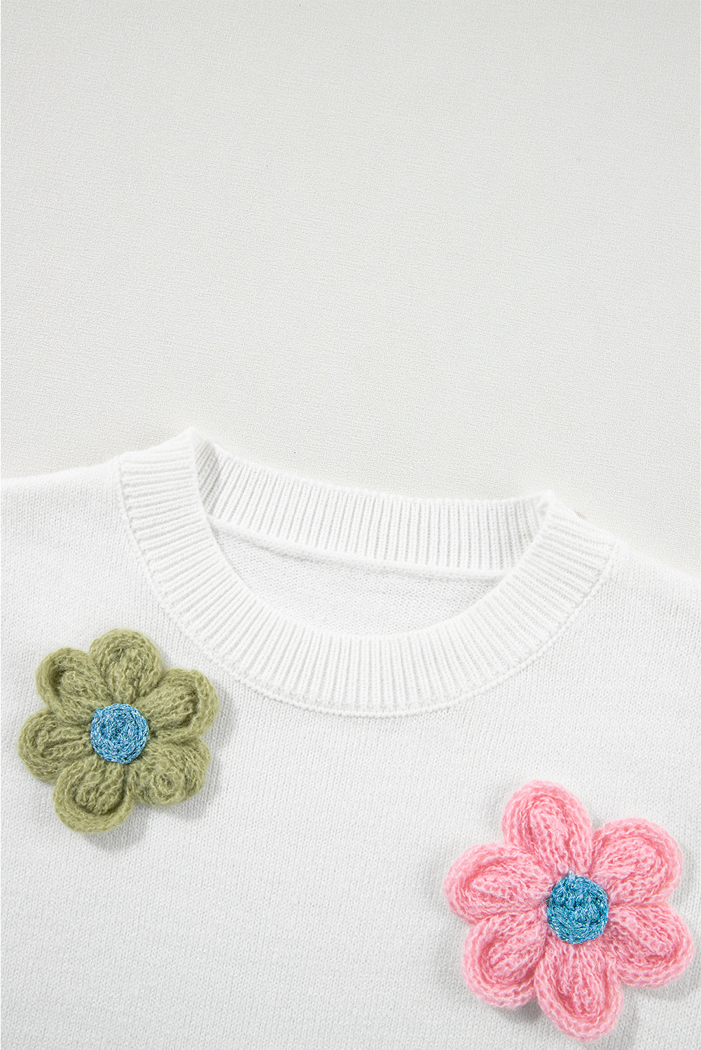 Weißer kurzarm-pullover mit niedlichen blumenapplikationen