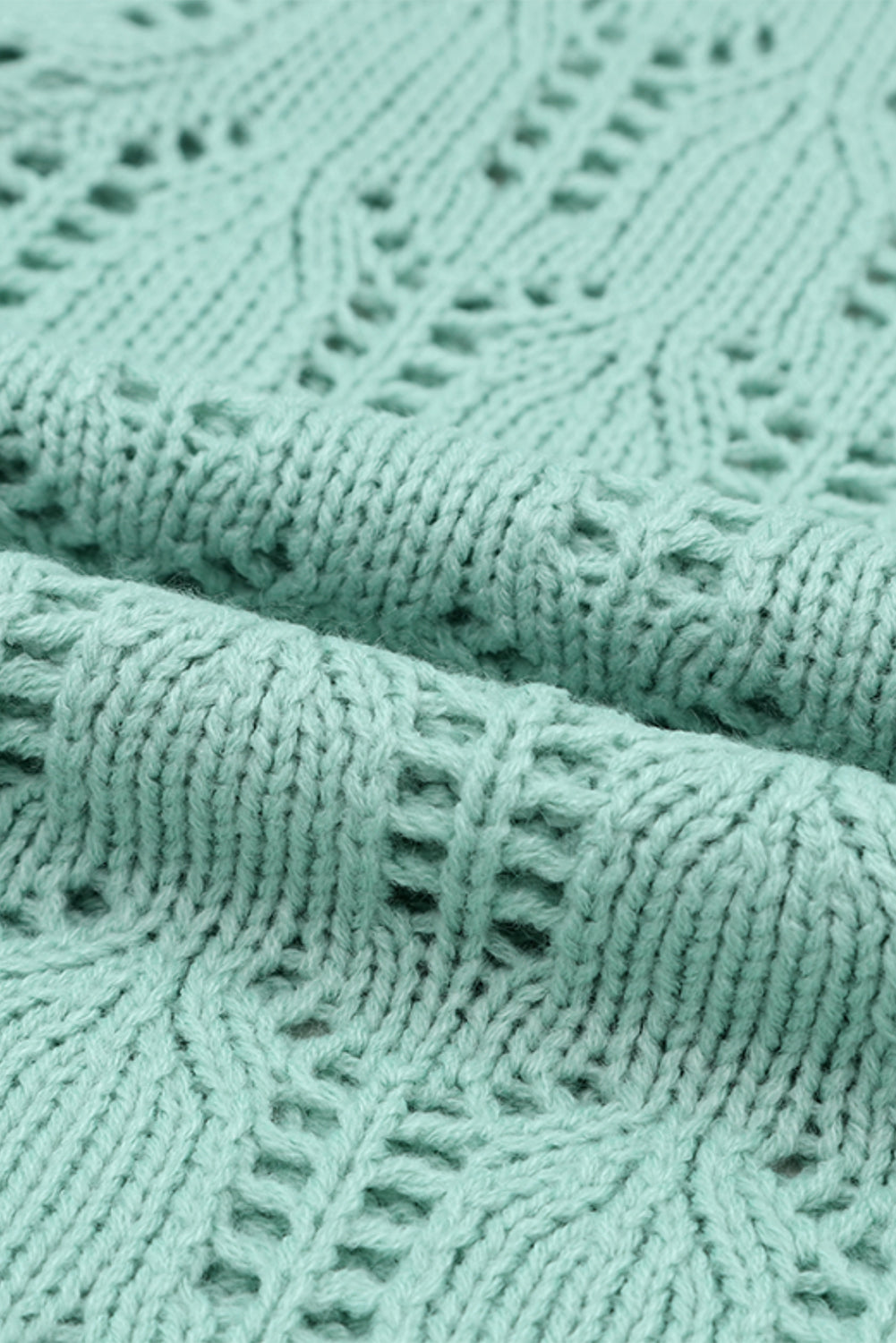 Grüner pointelle-pullover aus transparentem strick
