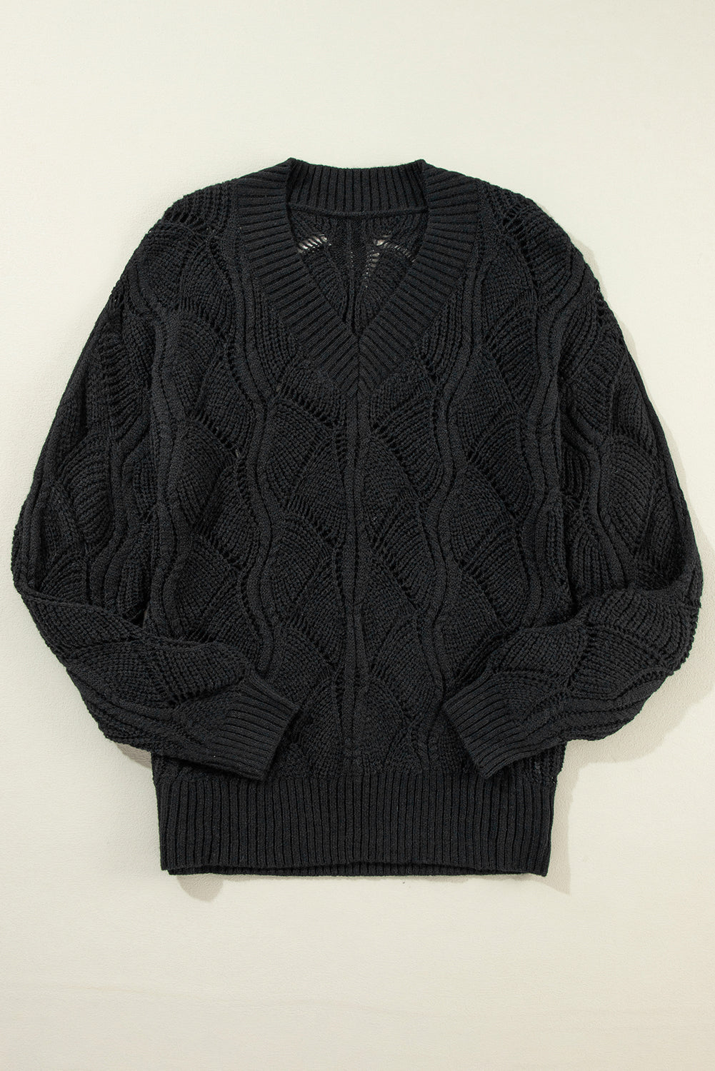 Schwarzer strickpullover mit v-ausschnitt und hohlen schultern