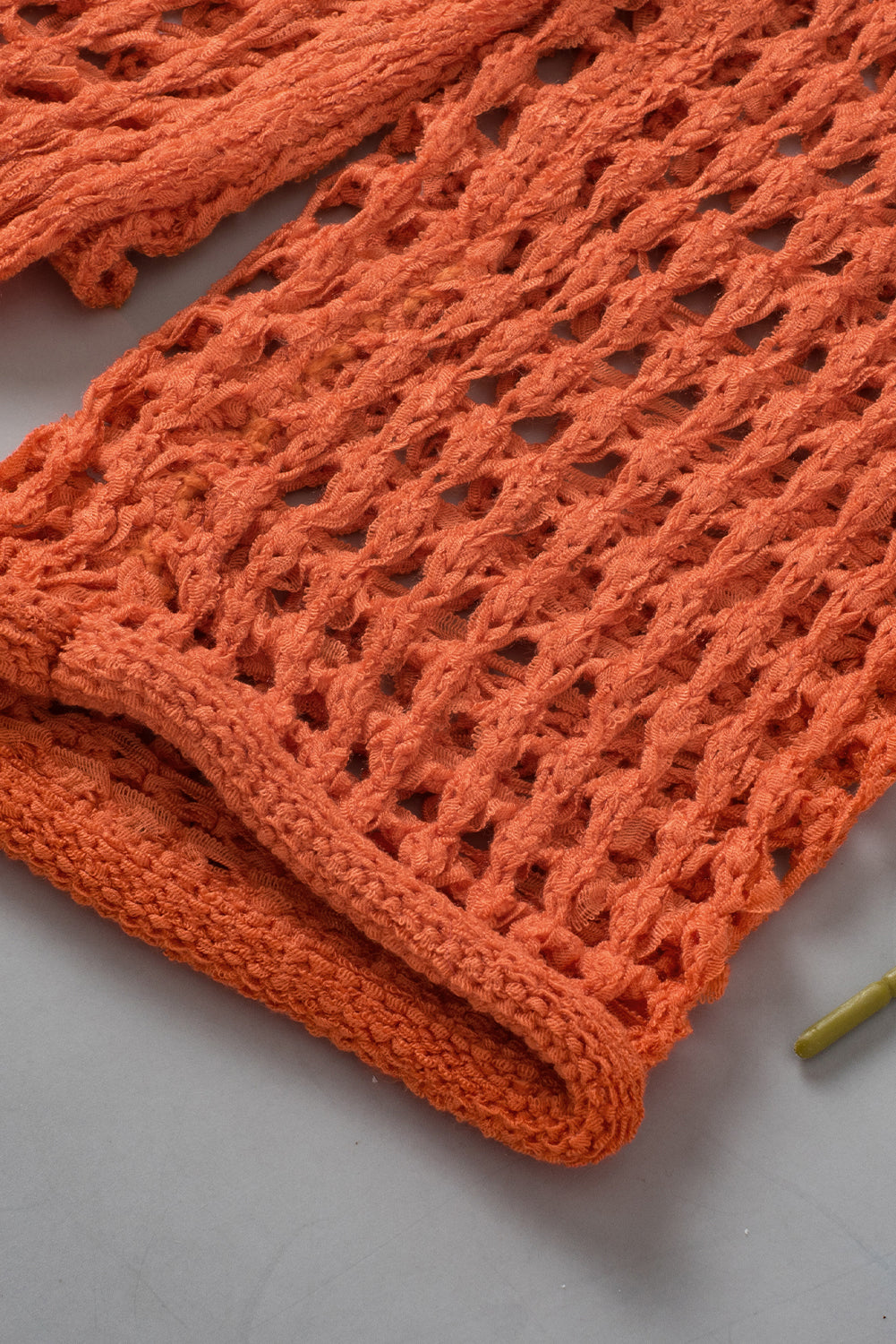 Orangefarbener tunika-pullover mit glockenärmeln und offenem häkelmuster