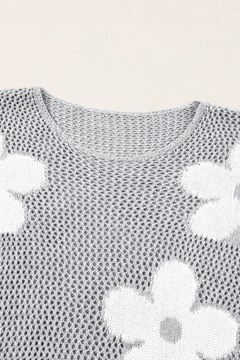 Hellgrauer pullover mit großer blume, hohl gestrickt und schulterfrei