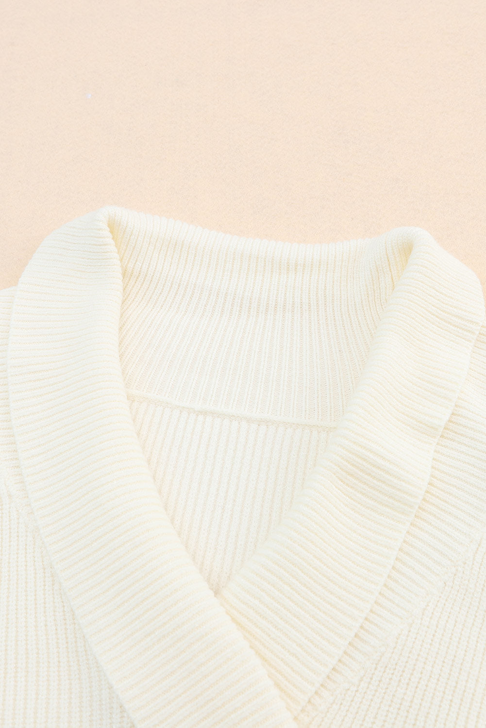 Beige gerippter pullover mit langen ärmeln und überwürfen