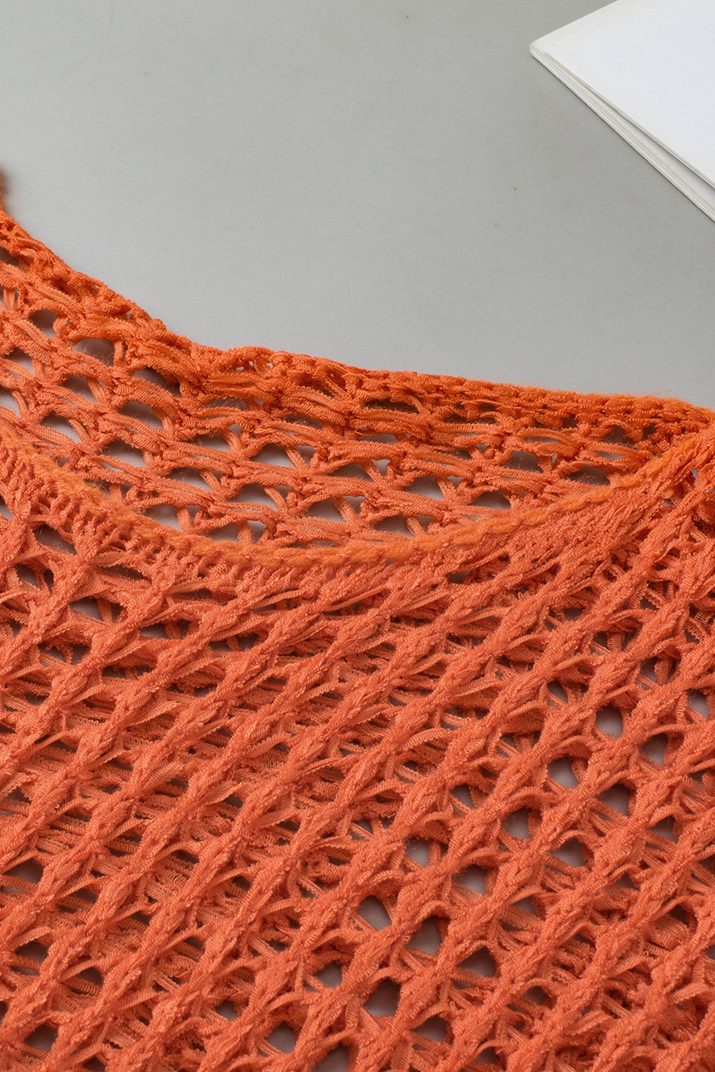 Orangefarbener tunika-pullover mit glockenärmeln und offenem häkelmuster