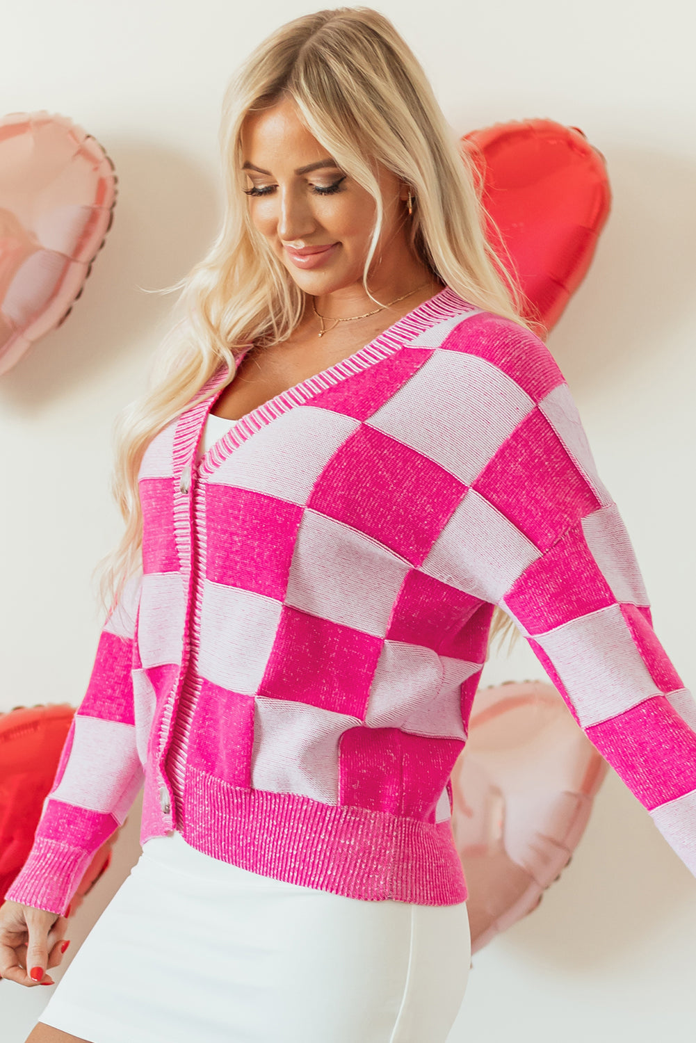Rosa karierte strickjacke mit v-ausschnitt und geknöpften schultern