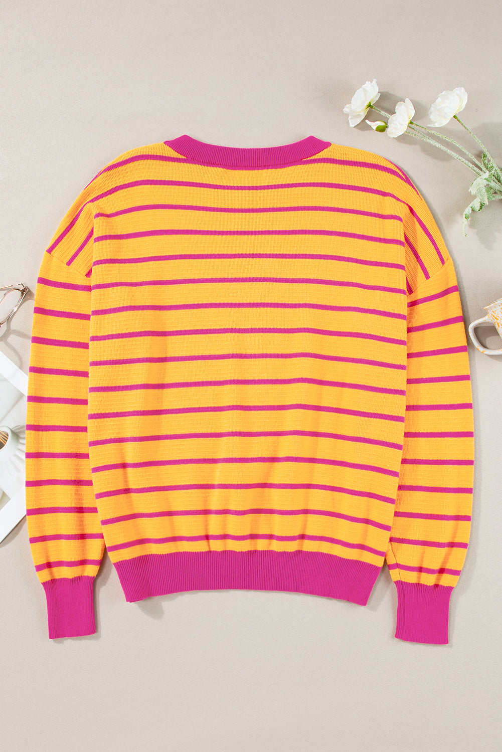 Orangefarbener gestreifter pullover mit rundhalsausschnitt und losen schultern