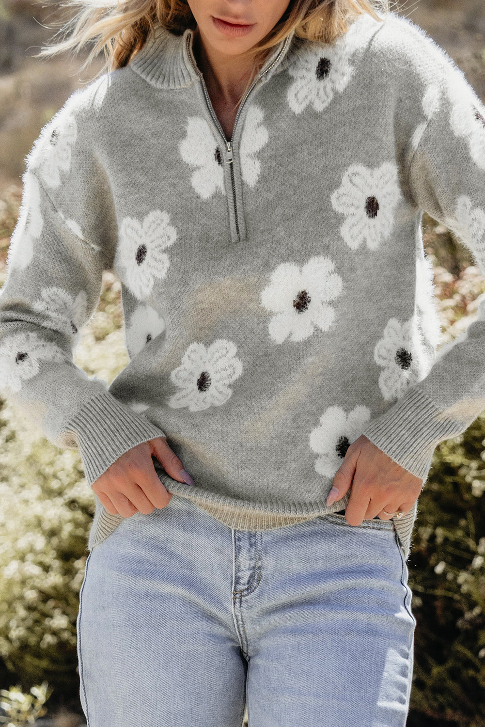Grauer pullover mit floralem muster und halbem reißverschluss an der schulter