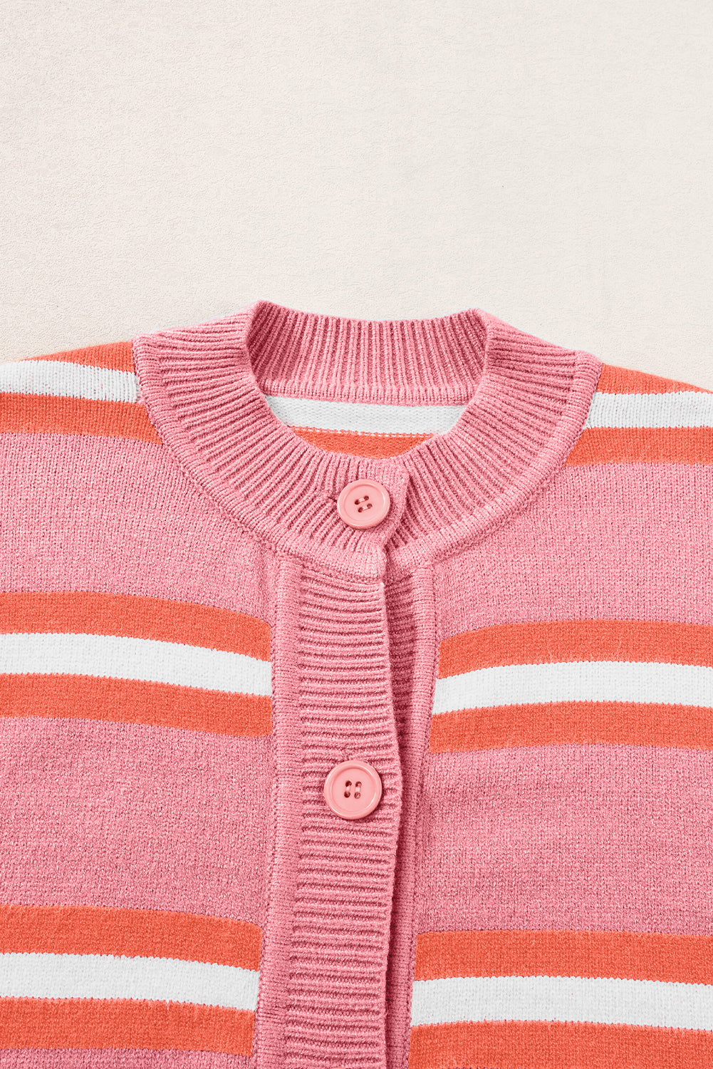 Rosa gestreifter strickpullover mit schulterknöpfen