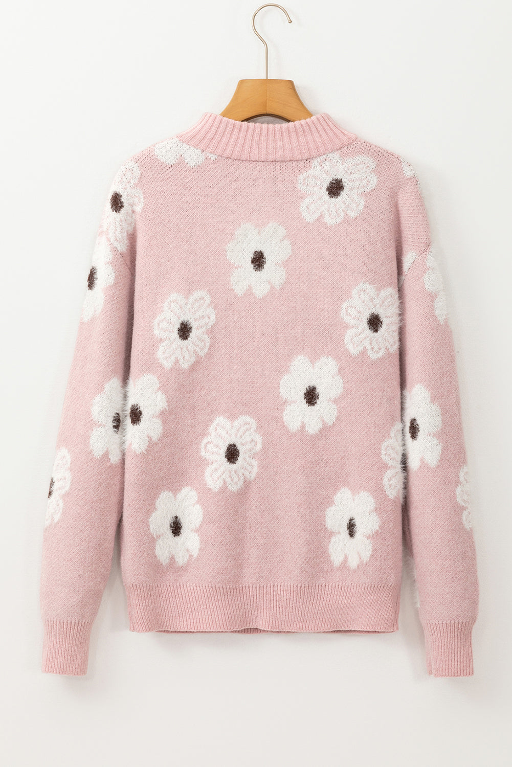Rosafarbener pullover mit blumenmuster und halbem reißverschluss an den schultern