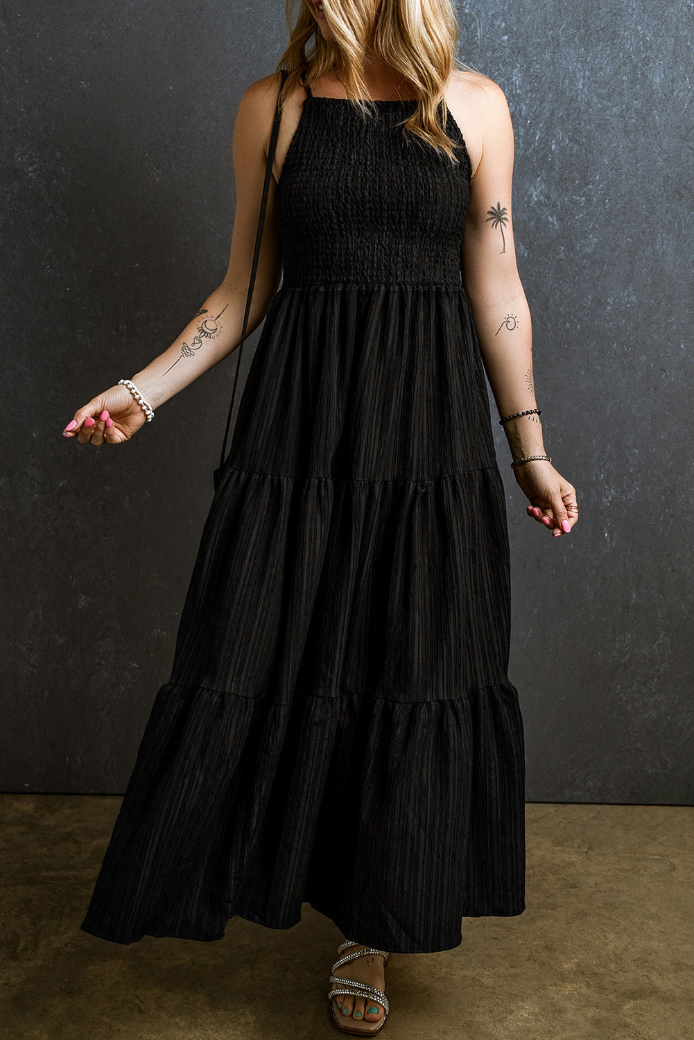 Schwarzes spaghettiträger-maxikleid mit plissierten falten