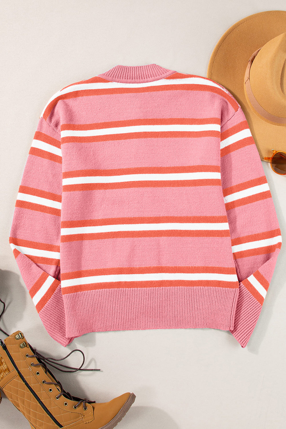 Rosa gestreifter strickpullover mit schulterknöpfen