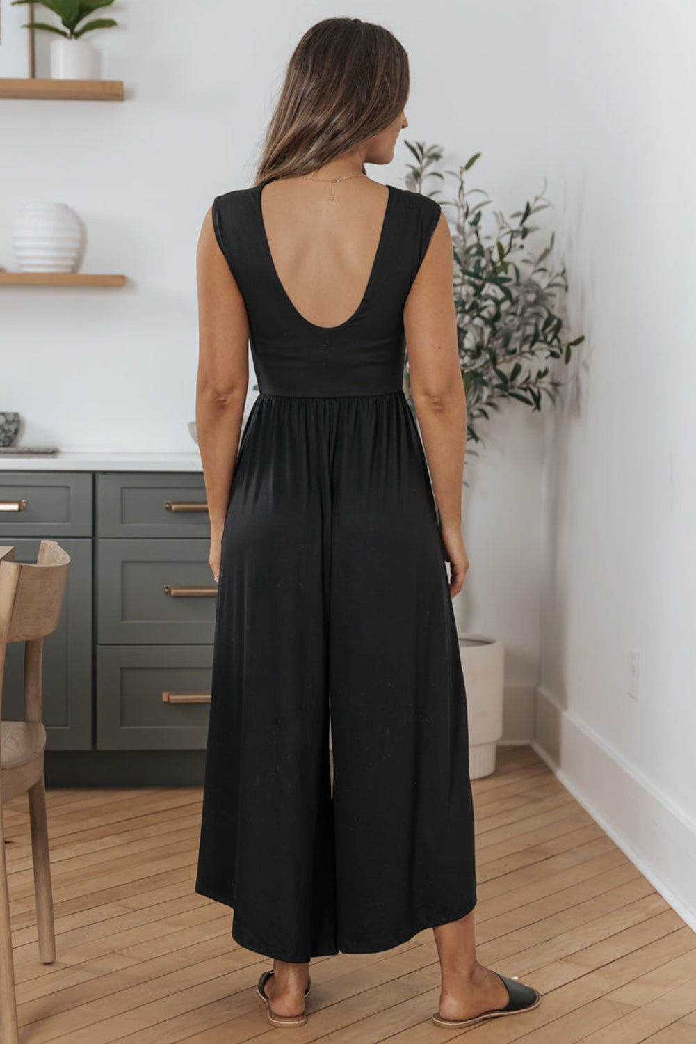 Schwarzer jumpsuit mit weitem bein und offenem rücken