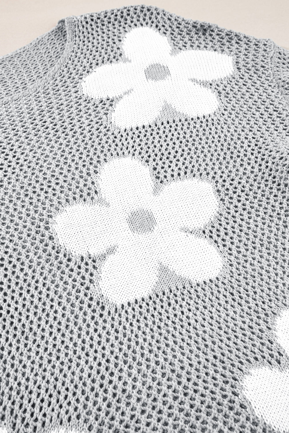 Hellgrauer pullover mit großer blume, hohl gestrickt und schulterfrei