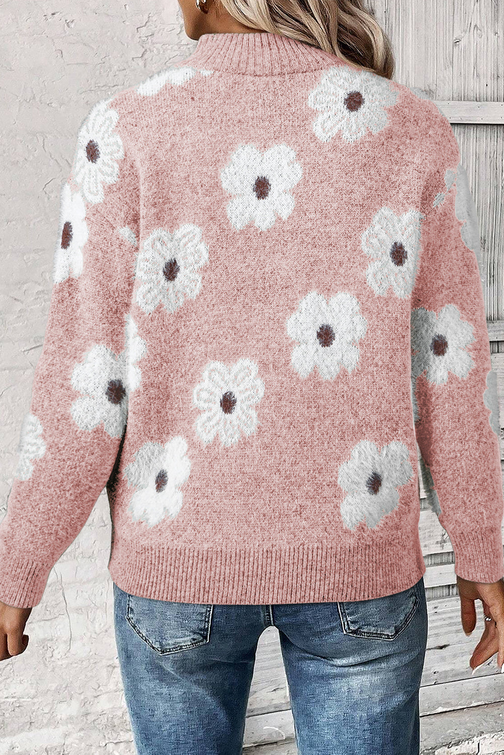 Rosafarbener pullover mit blumenmuster und halbem reißverschluss an den schultern