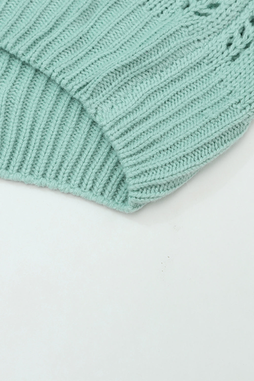 Grüner pointelle-pullover aus transparentem strick