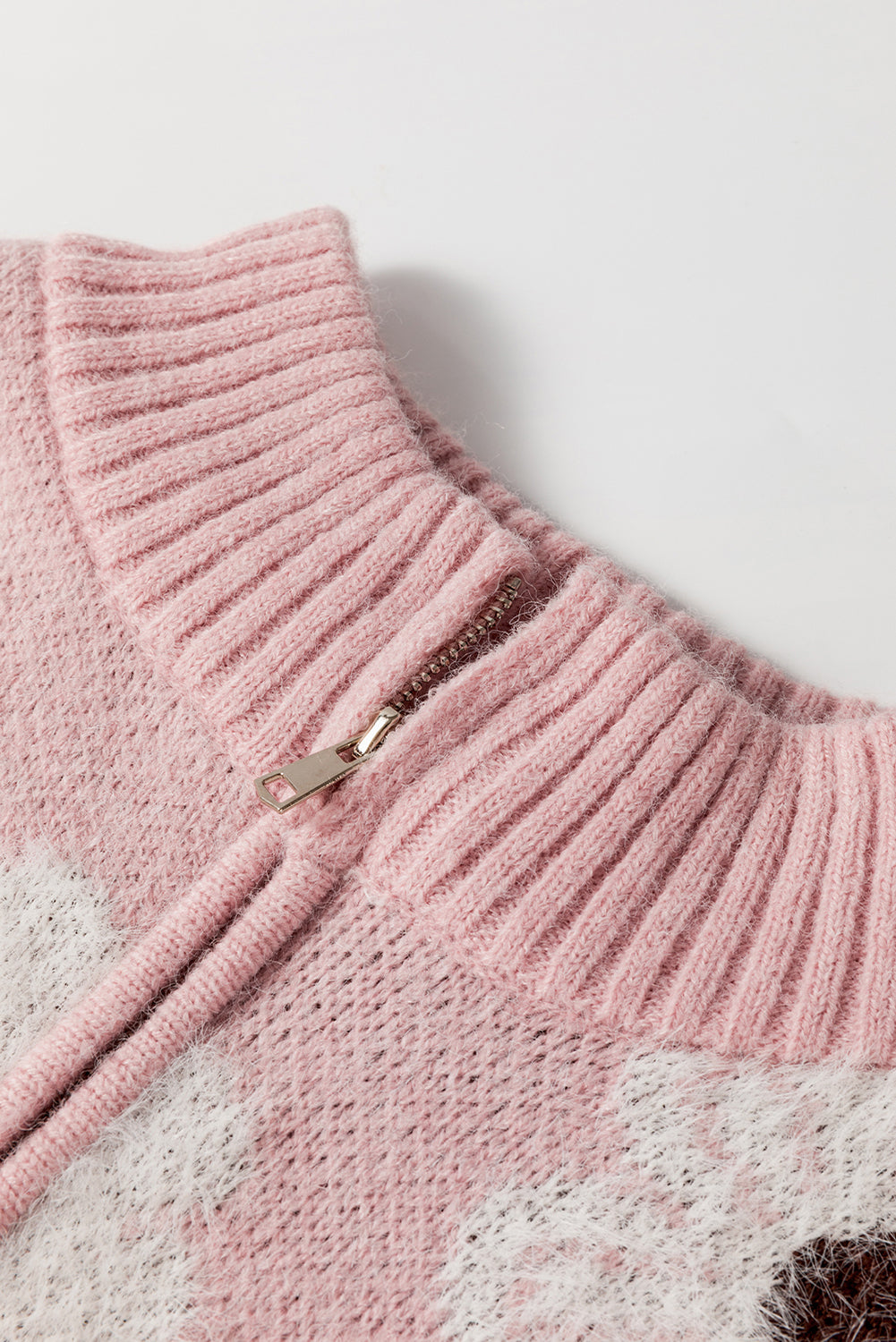 Rosafarbener pullover mit blumenmuster und halbem reißverschluss an den schultern