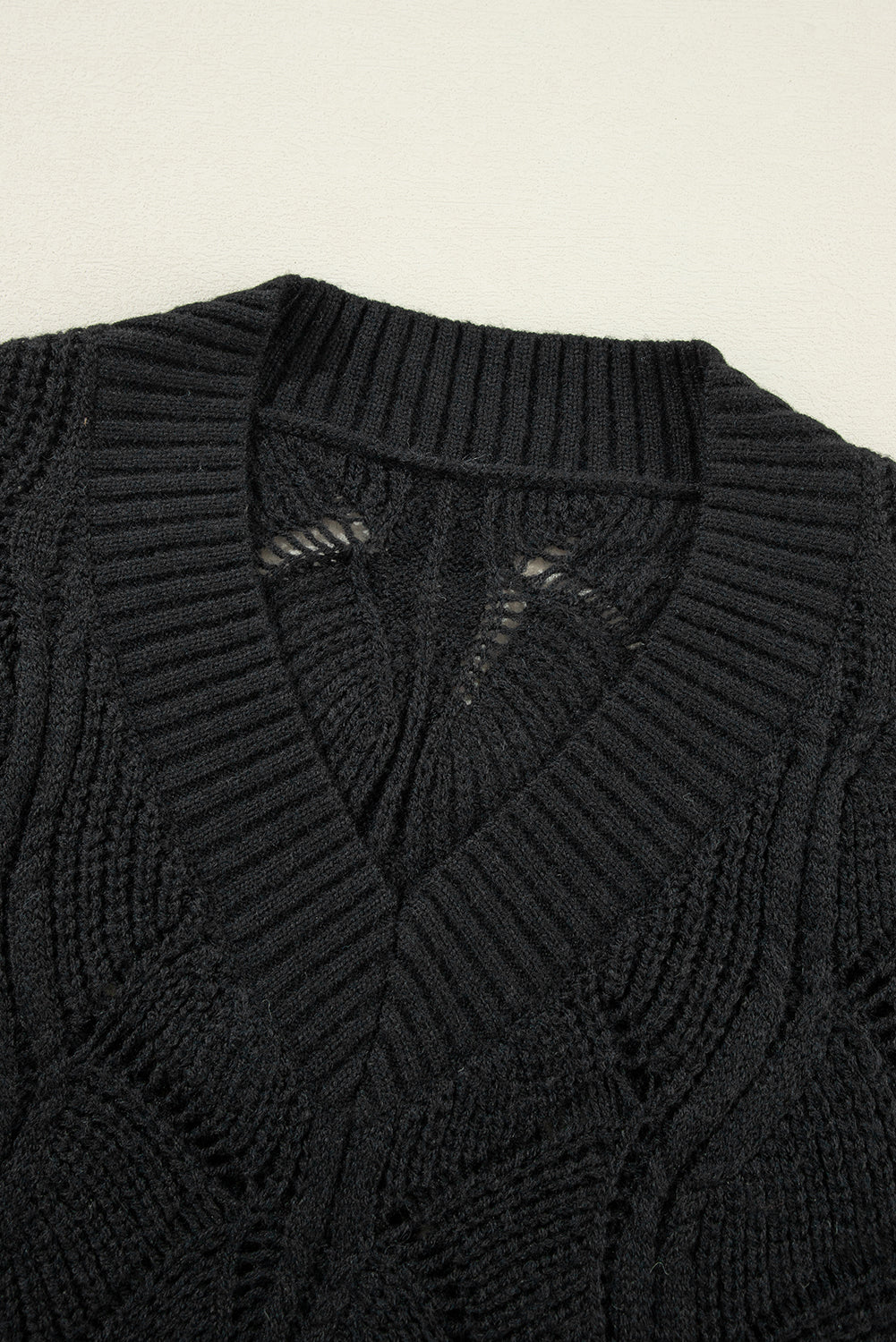 Schwarzer strickpullover mit v-ausschnitt und hohlen schultern