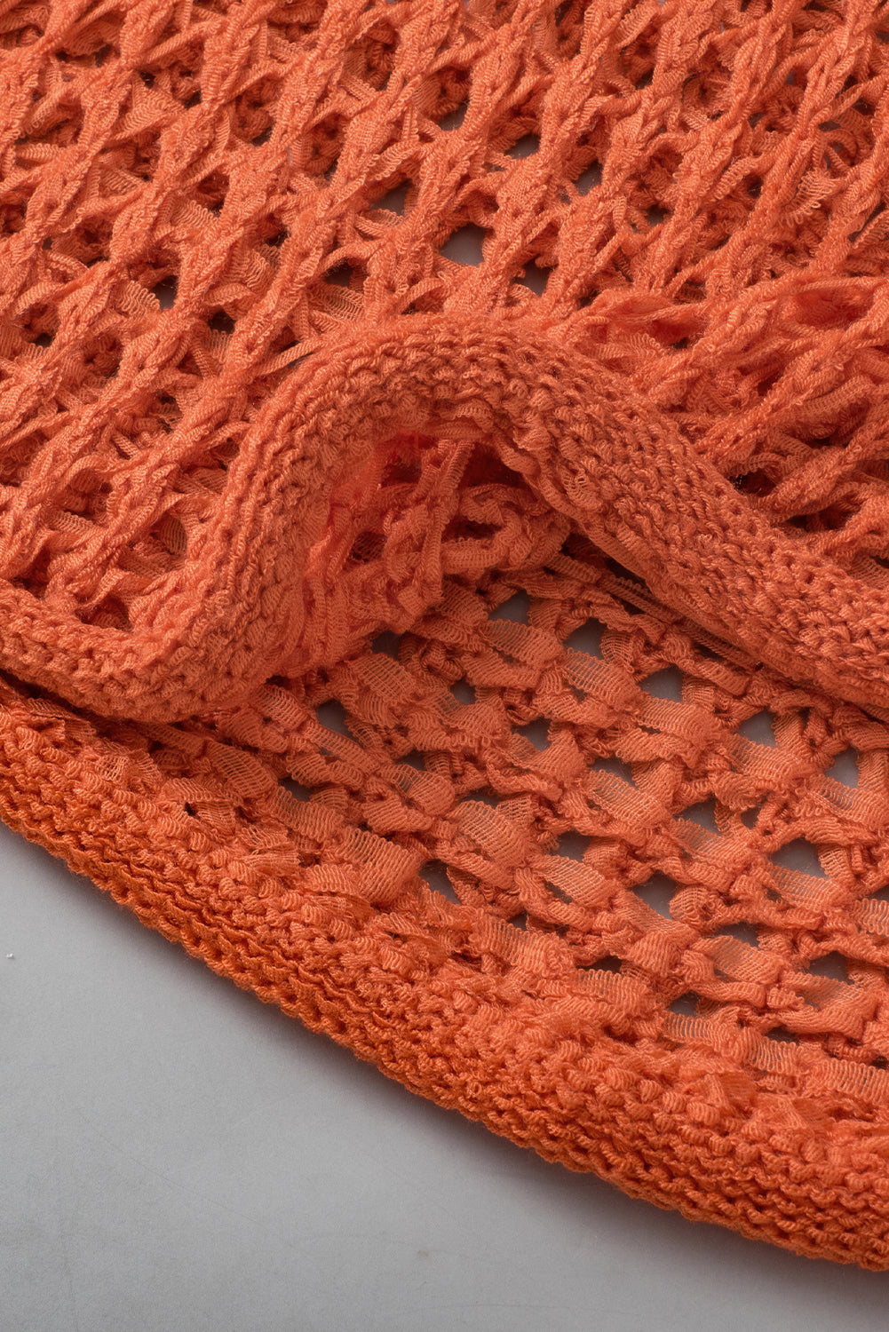 Orangefarbener tunika-pullover mit glockenärmeln und offenem häkelmuster