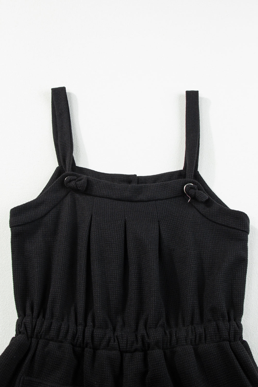 Schwarzer jumpsuit mit geknoteten trägern und strukturiertem kordelzug