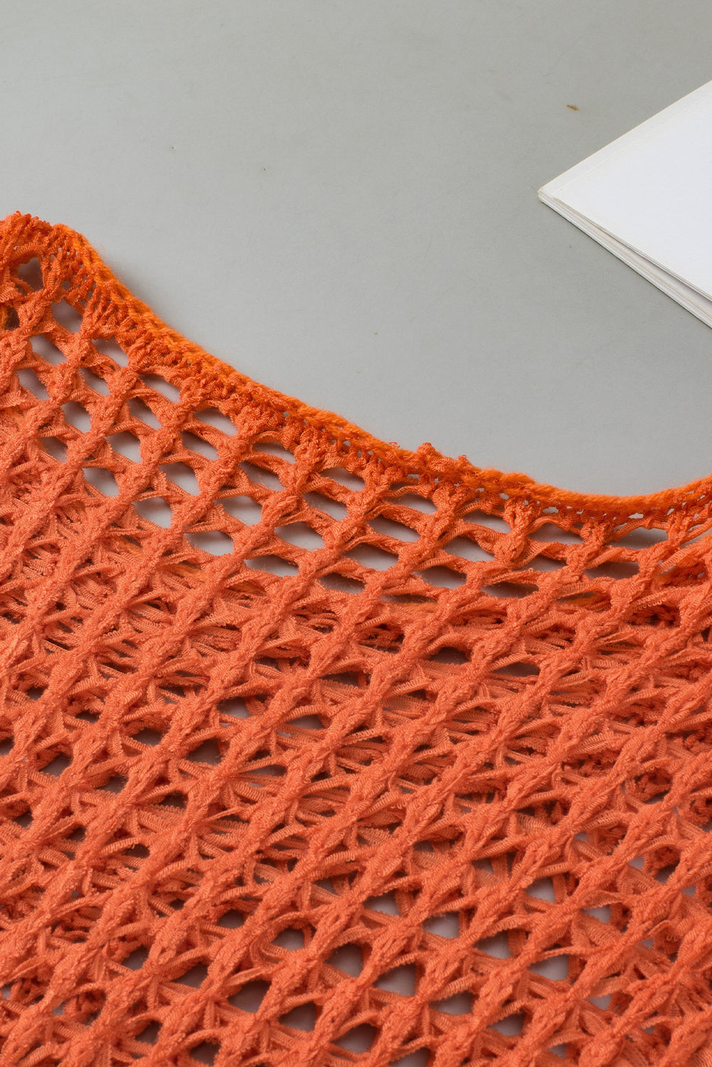 Orangefarbener tunika-pullover mit glockenärmeln und offenem häkelmuster