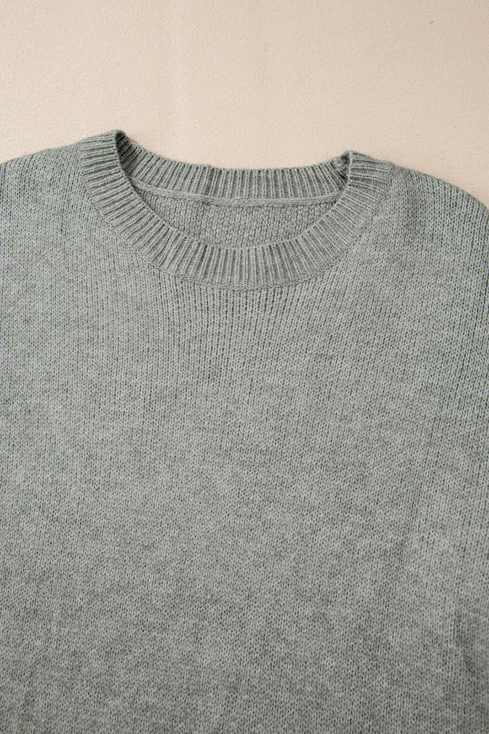 Hellgrauer pullover mit blumenärmeln und hängeschultern